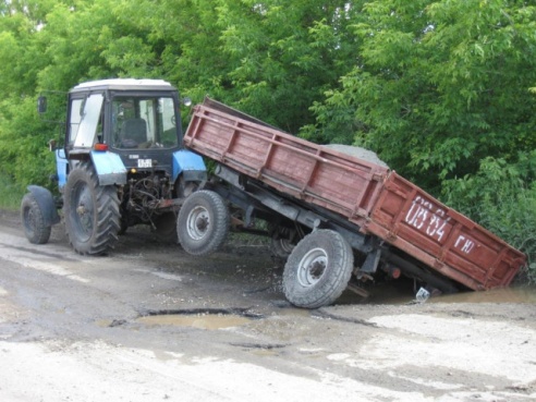 Фотофакт: в Светлогорске прицеп трактора провалился в яму в асфальте