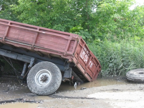 Фотофакт: в Светлогорске прицеп трактора провалился в яму в асфальте