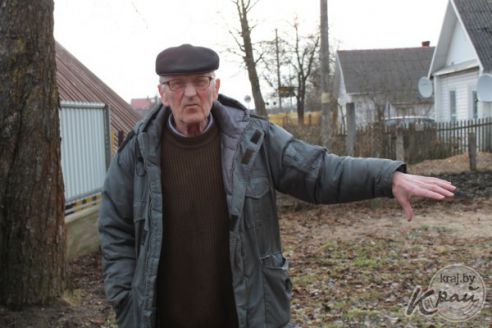 «Как только весна – во двор не зайти». Пенсионер в Вилейке несколько лет борется с лужей у забора (фото)