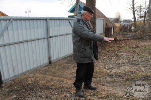 «Как только весна – во двор не зайти». Пенсионер в Вилейке несколько лет борется с лужей у забора (фото)